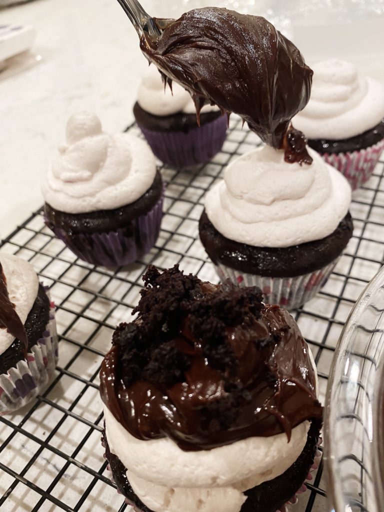 adding ganache to cupakes